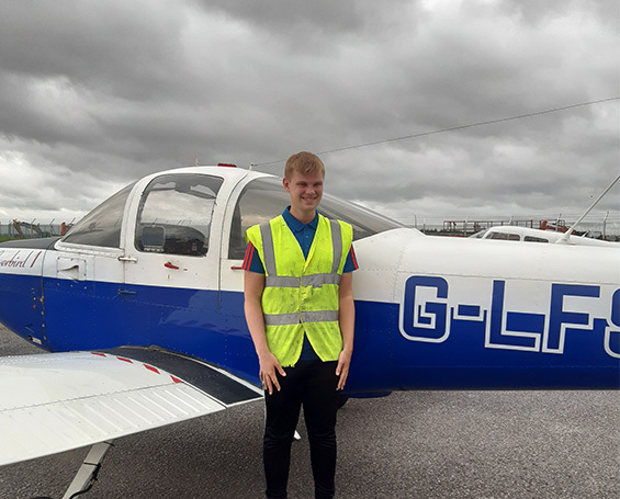 Former student Harry Taylor Marsh in front of light aircraft