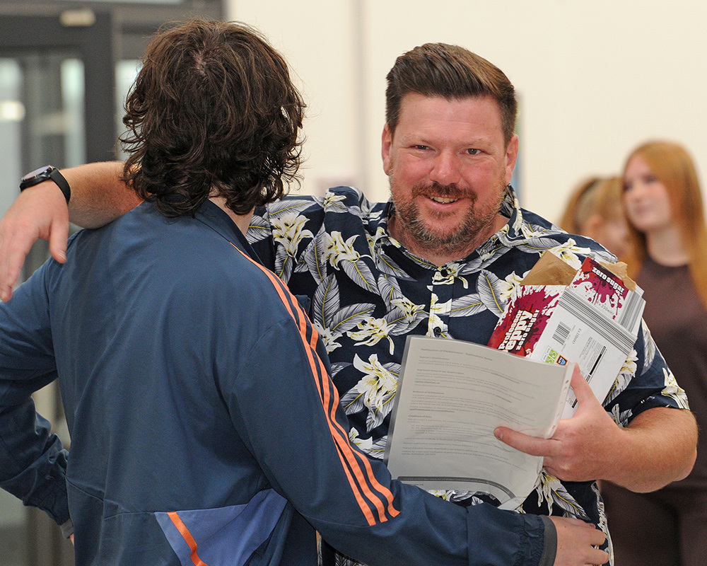 Dad hugs son at Vocational Results Celebration Morning