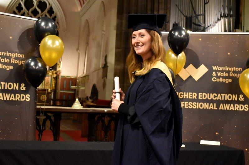 Student posing with scroll