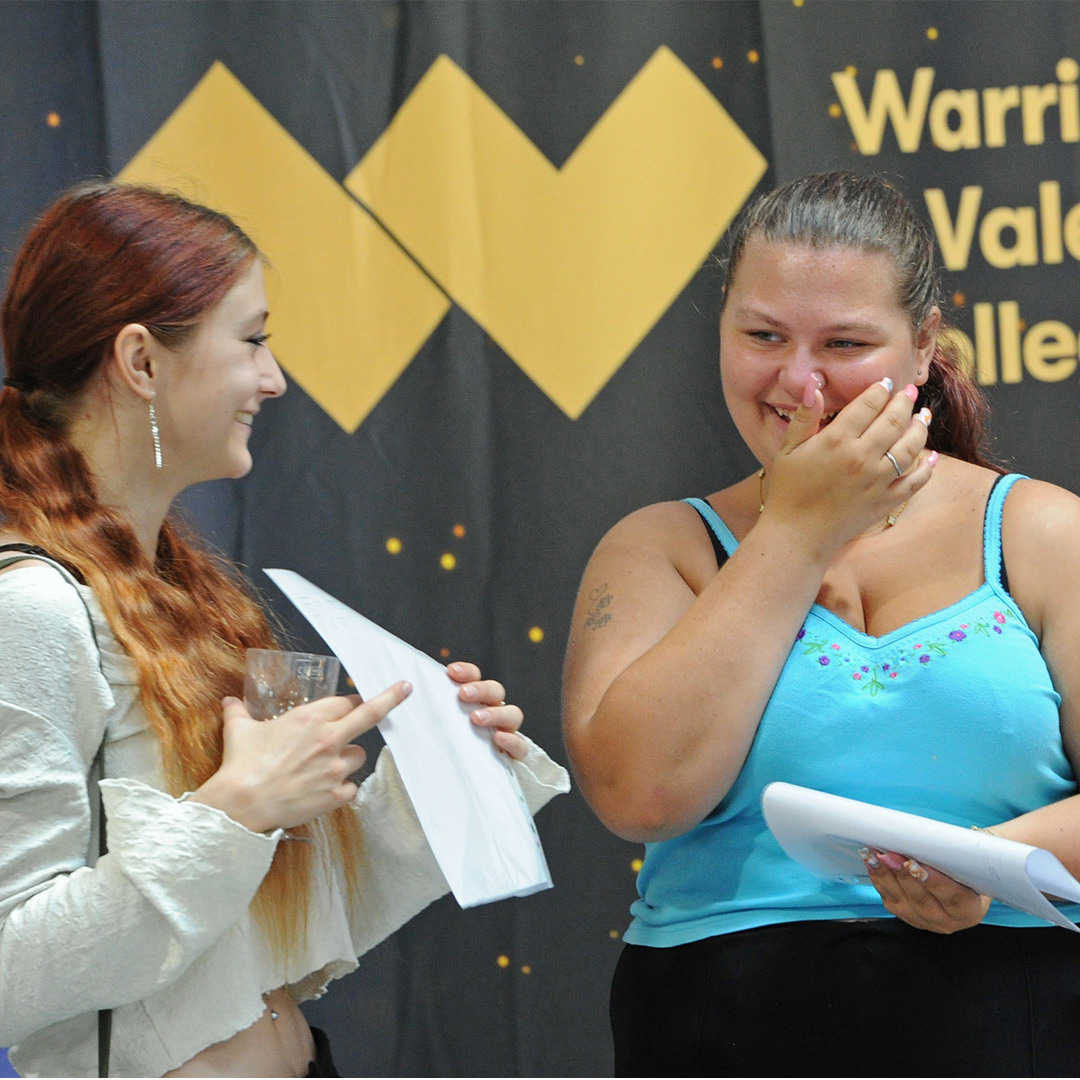 Two students laugh together after getting their resutls