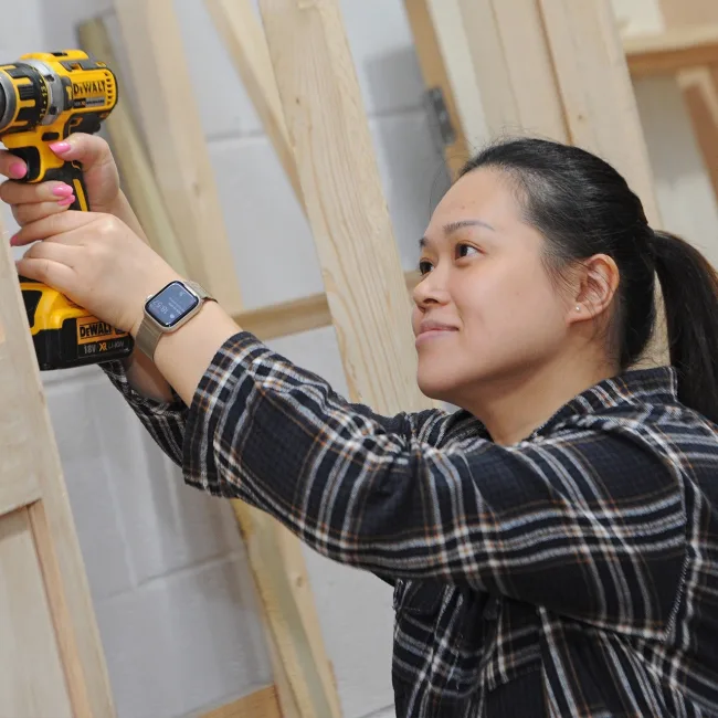 Female adult student working in carpentry workshop