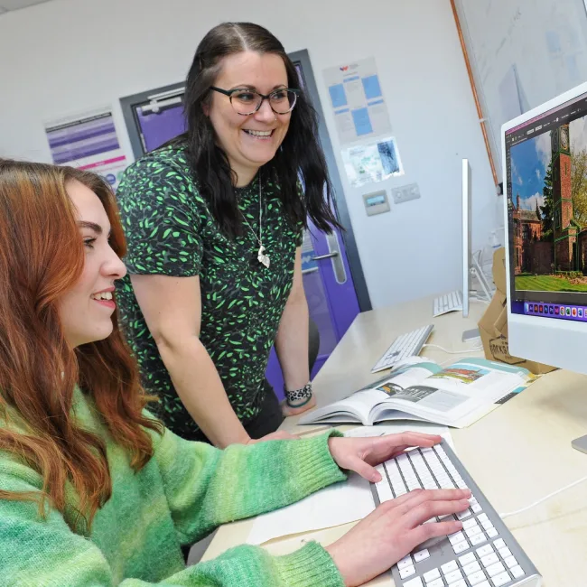 Graphic design student working on Mac with tutor