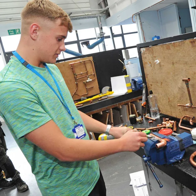 Male student working in plumbing workshop