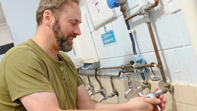 Adult plumbing student doing practical lesson