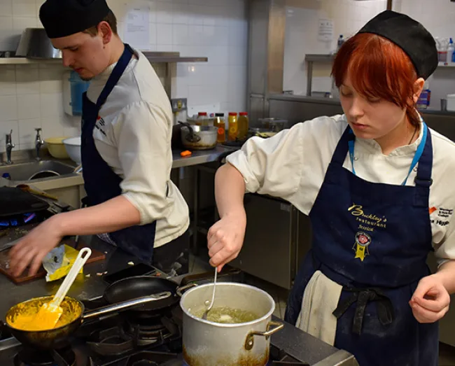 Catering student cooking on the hob