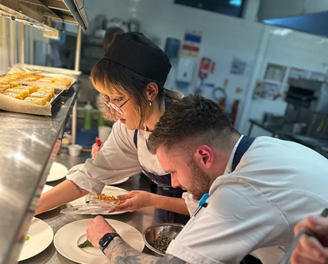 Students preparing food at the pass in Buckley's kitchen