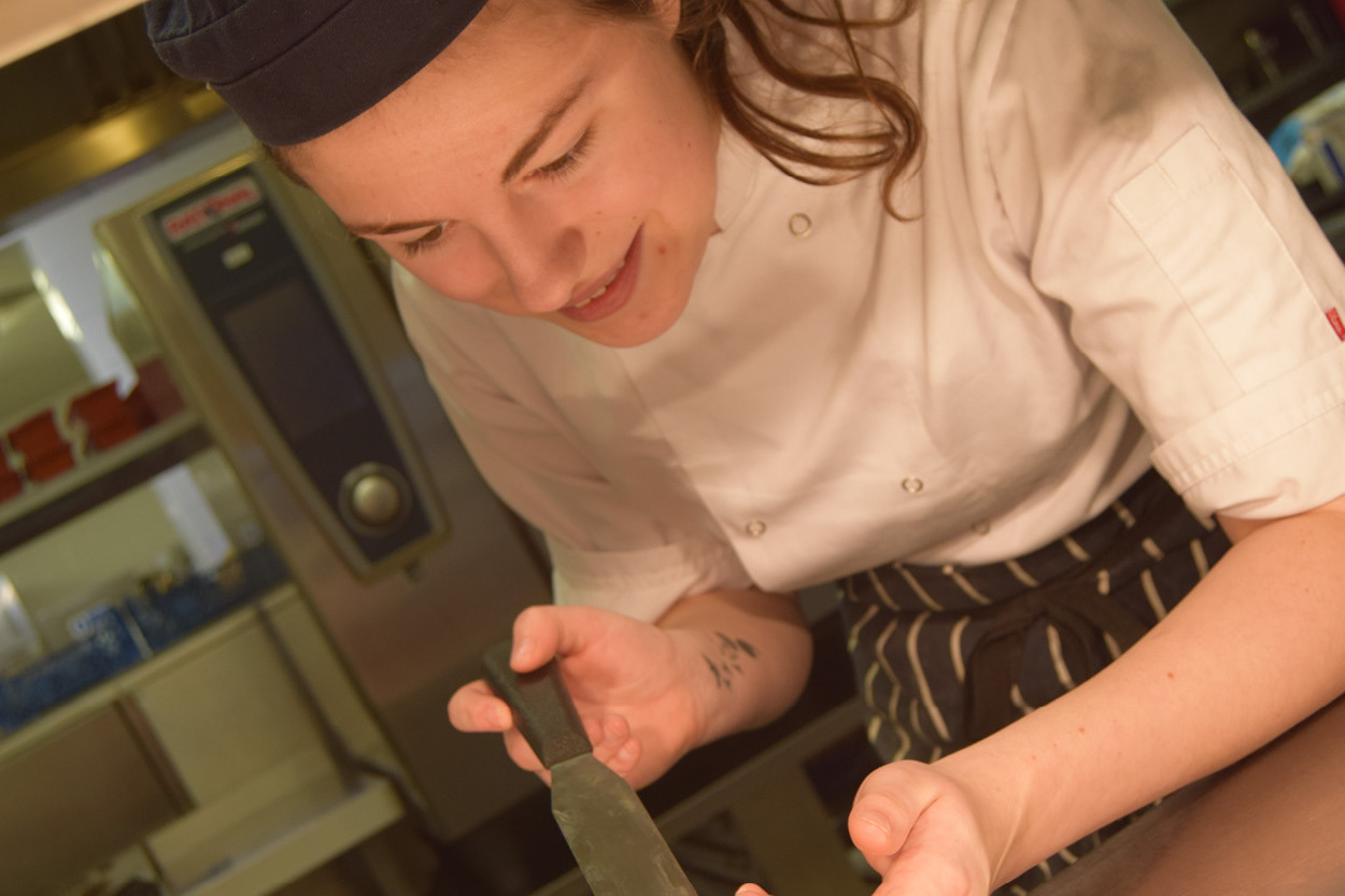 Student plating a dessert in Buckley's Kitchen